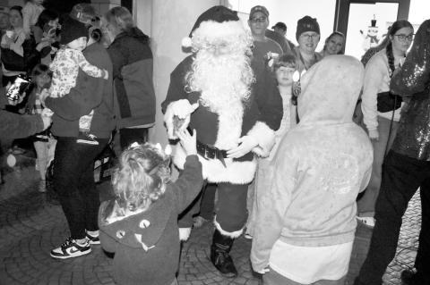 A youngster highfives Santa at the recent grand opening of Snowman Wonderland at the Reynolds Wellness Center. The jolly old elf is expected to be back in town later this week for the Seminole Chocolate Festival, which will be held from noon – 5 p.m. at