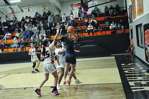 Bowlegs Lady Bison Kloe Oyler fights off Strother defenders for the basket. Staff Photo by Bill Anderson