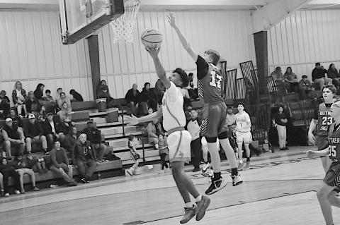Sasakwa Viking Darius Henderson goes up for the layup with Butner Eagle Ryan Bethany trying to block the shot. Staff Photo by Bill Anderson