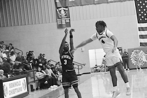 Wewoka Tiger Bill Stephens shoots over the Chieftain defender from three-point range. Staff Photo by Bill Anderson