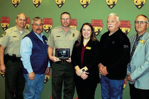 Gathered to present the Oklahoma Game Warden of the Year Award from the National Wild Turkey Federation is, from left, Nathan Erdman, Chief of Law Enforcement, Okla. Department of Wildlife Conservation; Mike Westmoland, NWTF state president; honoree Micha
