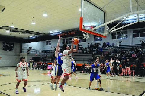 Wewoka Tiger Trae Woods fights off the Bethel defender for the basket Thursday. Staff Photo by Bill Anderson