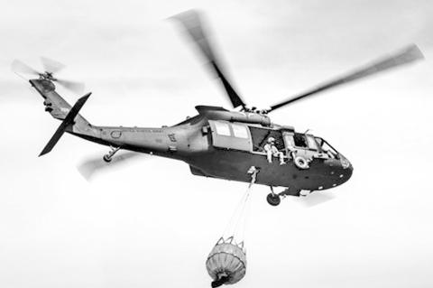 An Oklahoma Army National Guard UH-60 Black Hawk flies over the 702 Fire in Blaine County, Oklahoma after dropping more than 600 gallons of water on the fire, July 16, 2022. The Oklahoma National Guard is supporting the Oklahoma Forestry Services and loca