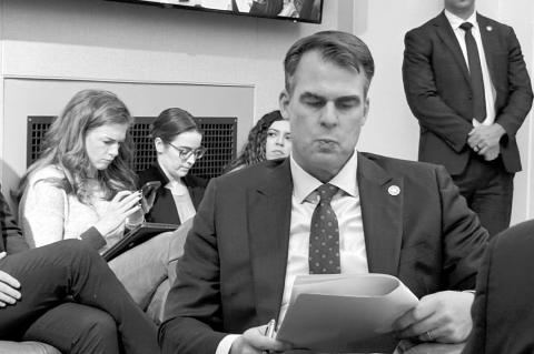 Gov. Kevin Stitt on Friday reviews budget figures during a meeting of the Oklahoma Board of Equalization. (Photo by Barbara Hoberock/Oklahoma Voice)