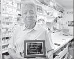 John Norman of Norman Drug in Wewoka holds the plaque he was presented with by the Wewoka Chamber of Business &amp; Industry for 100 years of service to the community. The award was presented at the Chamber’s banquet on March 30. (Courtesy photo)